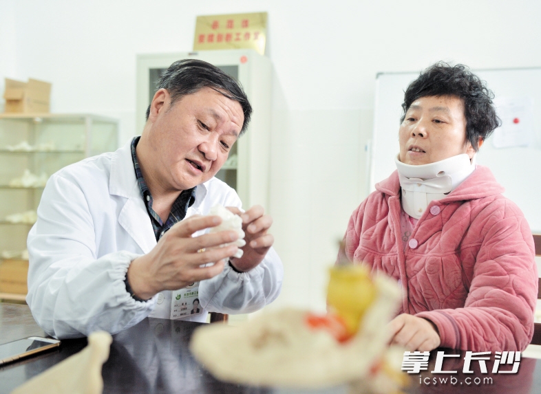 雷青拿著模型向患者介紹3D打印技術的優勢。 長沙晚報記者 鄒麟 攝